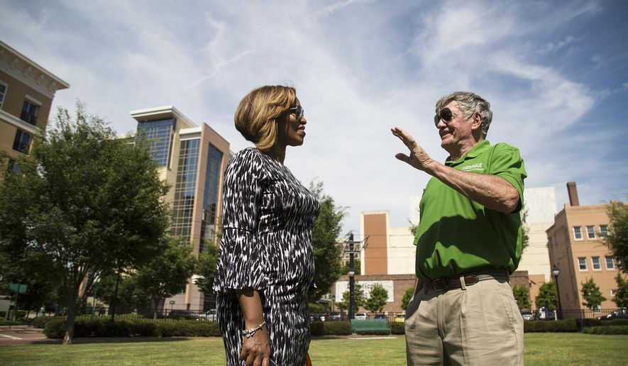 In this May 22, 2019 photo, Jasmine Duncan and Mike O'Hearn talk following a dedication ceremony for Farragut Park in downtown Norfolk, VA. The park's name stands out in Norfolk history, and is perhaps indicative of a shifting attitude: Many public spaces and buildings in the city bear the names of Confederate military men. Farragut's park is the first to recognize a Union officer. (Kaitlin McKeown/The Virginian-Pilot via AP)