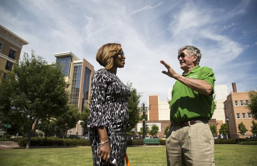 In this May 22, 2019 photo, Jasmine Duncan and Mike O'Hearn talk following a dedication ceremony for Farragut Park in downtown Norfolk, VA. The park's name stands out in Norfolk history, and is perhaps indicative of a shifting attitude: Many public spaces and buildings in the city bear the names of Confederate military men. Farragut's park is the first to recognize a Union officer. (Kaitlin McKeown/The Virginian-Pilot via AP)