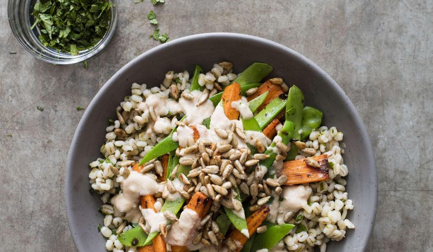 This undated photo provided by America's Test Kitchen in June 2019 shows a Barley Bowl with Roasted Carrots and Snow Peas in Boston. This recipe appears in the cookbook "Vegan for Everybody." (Steve Klise/America's Test Kitchen via AP)