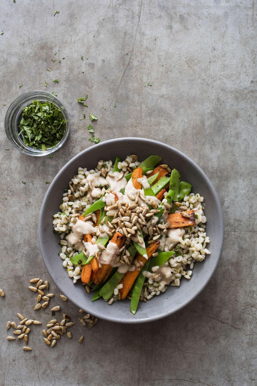 This undated photo provided by America's Test Kitchen in June 2019 shows a Barley Bowl with Roasted Carrots and Snow Peas in Boston. This recipe appears in the cookbook "Vegan for Everybody." (Steve Klise/America's Test Kitchen via AP)