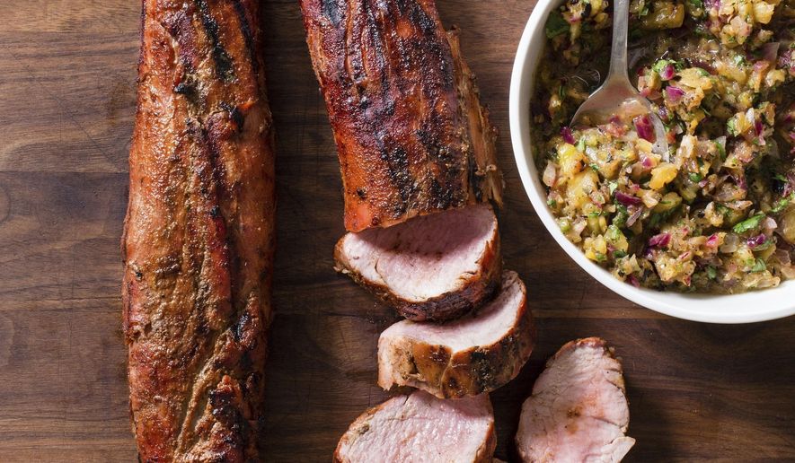 This undated photo provided by America's Test Kitchen in June 2019 shows Grill Roasted Pork Tenderloin with Grilled Pineapple Red Onion Salsa. This recipe appears in the cookbook "How to Roast Everything." (Carl Tremblay/America's Test Kitchen via AP)