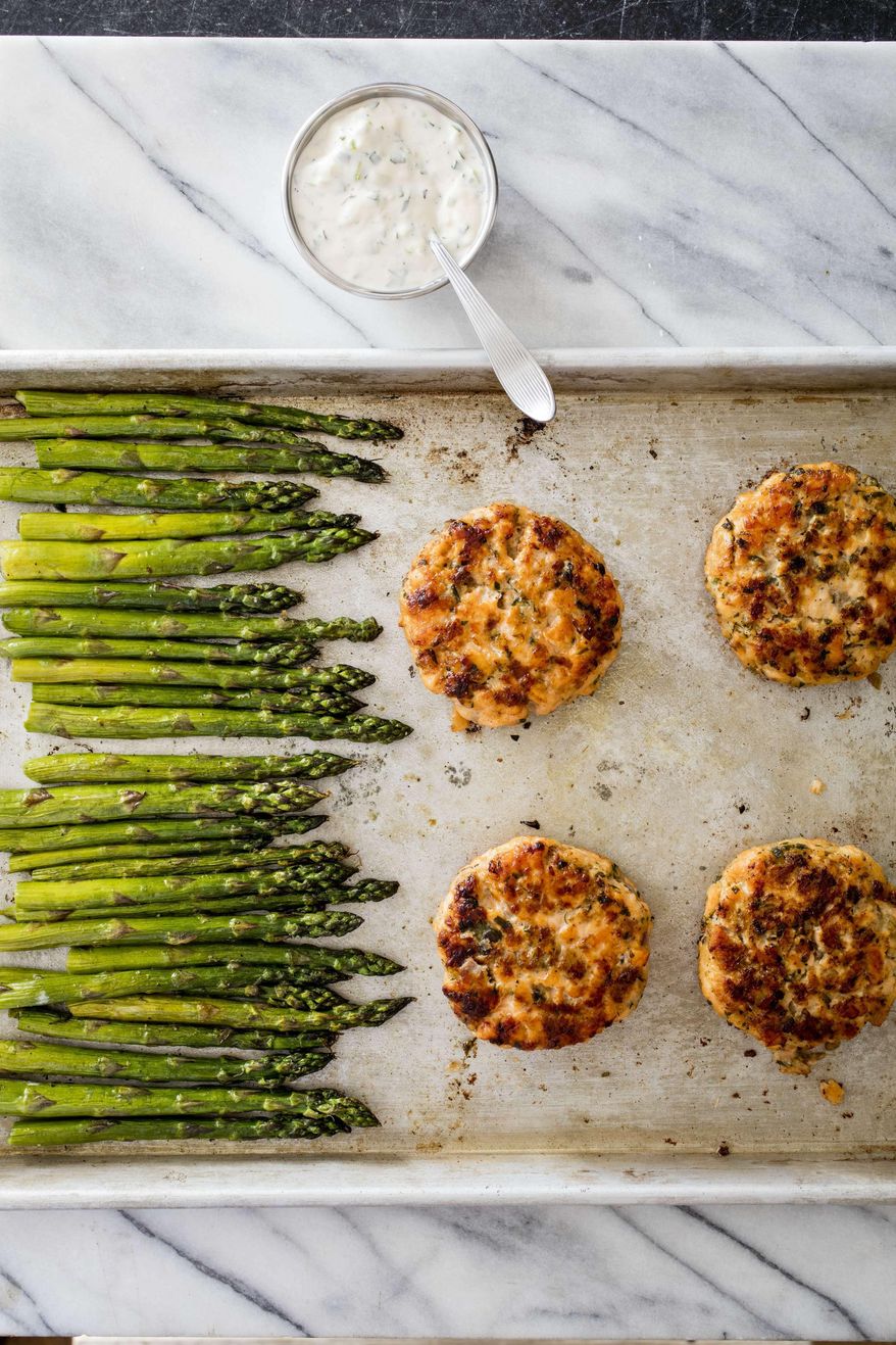 This undated photo provided by America's Test Kitchen in June 2019 shows Salmon Burgers. This recipe appears in the cookbook "One-Pan Wonders." (Daniel J. van Ackere/America's Test Kitchen via AP)