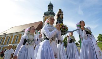 Women dressed in the traditional clothes of the Sorbs carry the statue of Virgin Mary during a procession in front of the Roman Catholic pilgrimage church in Rosenthal, eastern Germany, Monday, June 10, 2019. Traditionally on White Monday catholic faithful Sorbs, a Slavic minority near the German-Polish border, celebrate an open-air mass in the small village east of Dresden. (AP Photo/Jens Meyer) **FILE**
