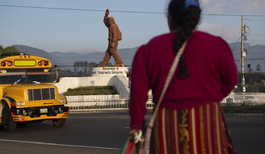 In this June 7, 2019, photo, a Quiche indigenous woman stands facing a monument that pays homage to migrants from the town of Salcaja, at the entrance to the town in Guatemala. Central Americans still dream of reaching the United States as Mexico cracks down on migrants entering the country. (AP Photo/Moises Castillo)