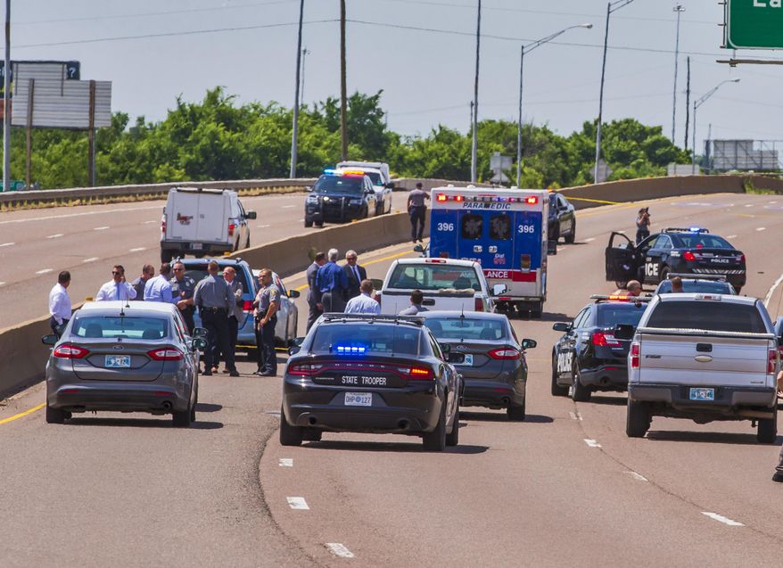 Crews work the scene a fatal officer involved shooting on I-35 in Oklahoma City Okla. on Monday, June 10, 2019. (Chris Landsberger/The Oklahoman via AP)