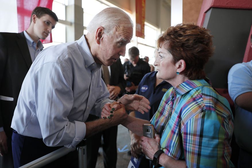 Democratic presidential candidate former Vice President Joe Biden, left, takes a moment to speak with Cheri Scherr of Pella about immigration after a town hall meeting, Tuesday, June 11, 2019, in Ottumwa, Iowa. (AP Photo/Matthew Putney)