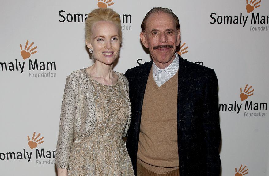 In this Oct. 23, 2013, file photo, artist Peter Max, right, and his wife Mary Max, left, attend the Somaly Mam Foundation Gala in New York. Authorities say Mary Max, 53, was found dead Sunday, June 9, 2019, in New York, of a suspected suicide amid a family fight over her husbands work. Her death comes two weeks after The New York Times published a story detailing legal battles over the work of Peter Max, a prolific creator of colorful, psychedelic art who is now living with dementia at age 81. (Photo by Andy Kropa/Invision/AP, File)