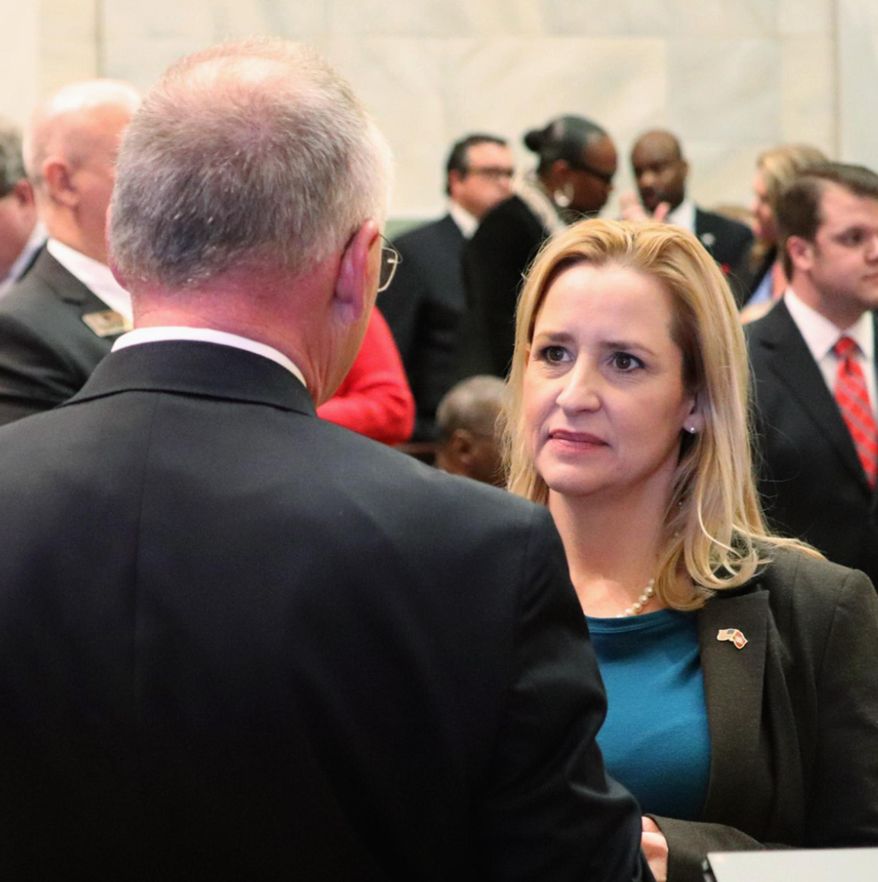 FILE - In this Feb. 12, 2018, file photo, Arkansas Attorney General Leslie Rutledge, right, speaks with Parliamentarian Buddy Johnson in the Arkansas House chamber in Little Rock. A federal lawsuit alleges the voting system for some Arkansas judges violates black residents' rights by diluting the strength of the vote. Lawyers for the NAACP Legal Defense Fund filed the lawsuit Monday, June 10, 2019. A spokeswoman says state Attorney General Leslie Rutledge is reviewing the complaint. (AP Photo/Kelly P. Kissel File)
