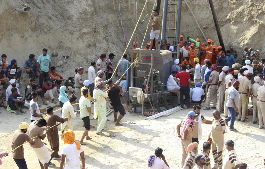 In this Monday, June 10, 2019 photograph, people try to rescue a 2-year-old boy who fell deep into an unused village well in Sangrur, Punjab state, India. The boy was brought to a hospital after he was removed from the well but doctors said he had died. The boy fell into the well last Thursday and state authorities dug a parallel well to save the boy. (AP Photo)
