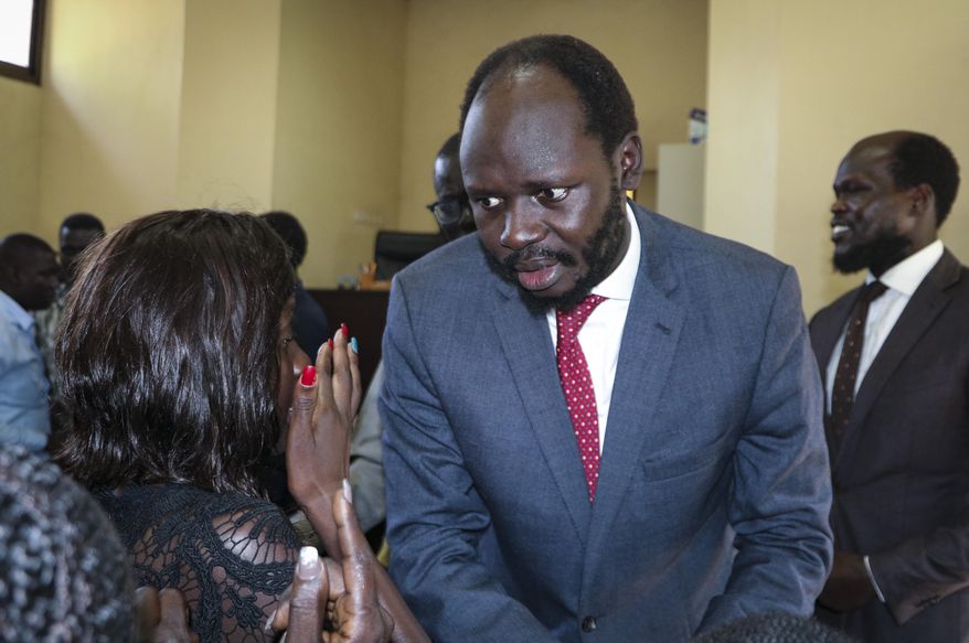 Prominent South Sudanese activist and economist Peter Biar Ajak prepares to embrace his wife Nyathon Hoth Mai, left, as she weeps after he was sentenced to two years in prison, in a courtroom in the capital Juba, South Sudan Tuesday, June 11, 2019. Relatives wept as Ajak and five other men were sentenced for inciting an uprising in the country's main national security prison in October, while their lawyers vowed to appeal and Amnesty International said it had received reports of witness intimidation. (AP Photo/Sam Mednick)
