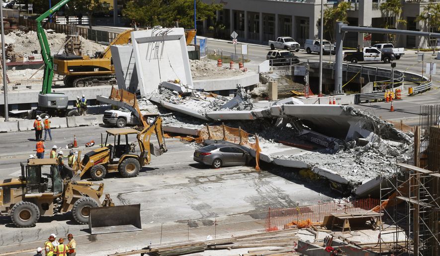 FILE - In this March 16, 2018 file photo crushed cars are shown under a section of a collapsed pedestrian bridge near Florida International University in the Miami area. A federal workplace safety agency says engineers had knowledge of extensive cracking and failed to order to close a street and shore up a pedestrian bridge before it collapsed and killed six people at a Miami university last year. On Tuesday, June 11, 2019 a report by the U.S. Occupational Safety and Health Administration concluded the size of the cracks warranted the street be shut down immediately. (AP Photo/Wilfredo Lee)