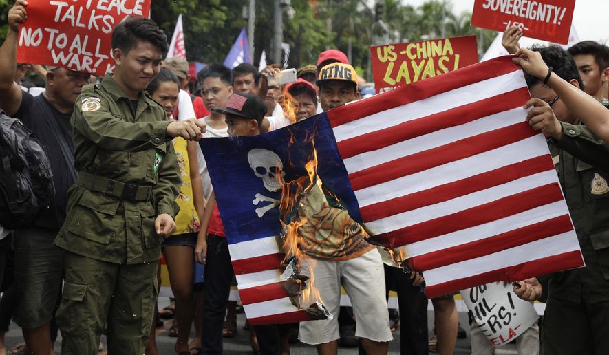 Protesters burn a mock U.S. flag during a rally near the U.S. Embassy in Manila, Philippines, to mark the Independence Day on Wednesday, June 12, 2019. The group said they condemn the administration of Philippine President Rodrigo Duterte for it&#39;s alleged subservience to the dictates of U.S. and China. They also demanded an end to the Visiting Forces Agreement, VFA, and the Enhanced Defense Cooperation Agreement, EDCA. (AP Photo/Aaron Favila)