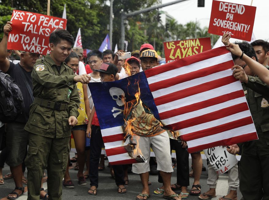 Protesters burn a mock U.S. flag during a rally near the U.S. Embassy in Manila, Philippines, to mark the Independence Day on Wednesday, June 12, 2019. The group said they condemn the administration of Philippine President Rodrigo Duterte for it&#39;s alleged subservience to the dictates of U.S. and China. They also demanded an end to the Visiting Forces Agreement, VFA, and the Enhanced Defense Cooperation Agreement, EDCA. (AP Photo/Aaron Favila)