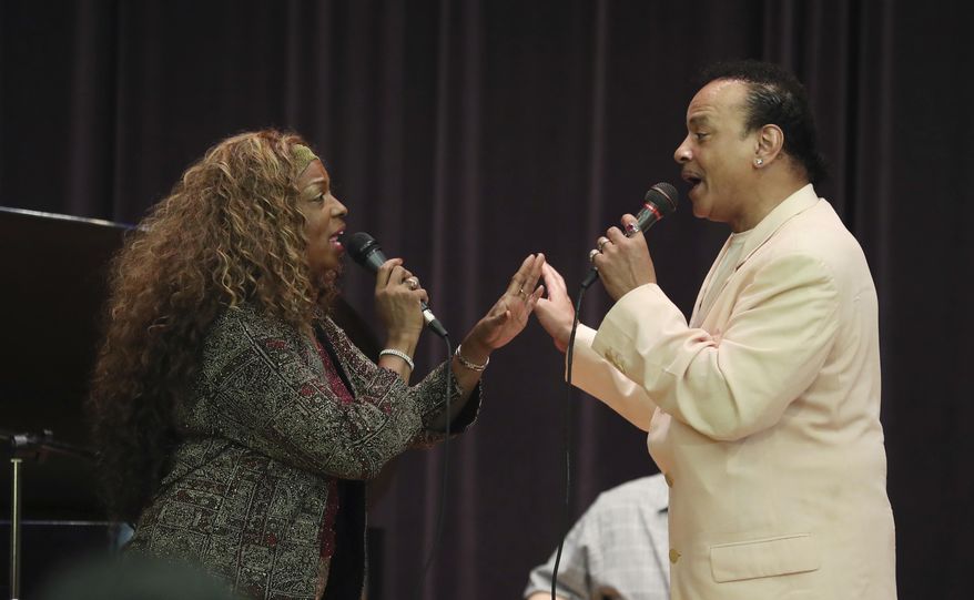 FILE- In this July 31, 2018 file photo, singers Mark Scott of The Miracles and Joan Belgrave, left, perform in Detroit. The Charles H. Wright Museum of African American History is marking Black Music Month with a concert featuring many of Detroit's prominent musical, visual and literary artists. Belgrave is producing and performing at the June 27, 2019 concert, "Our Music Our Lives." The show aims to explore connections between music and the black experience in America, and will include works from slavery through modern times.(AP Photo/Carlos Osorio, File)