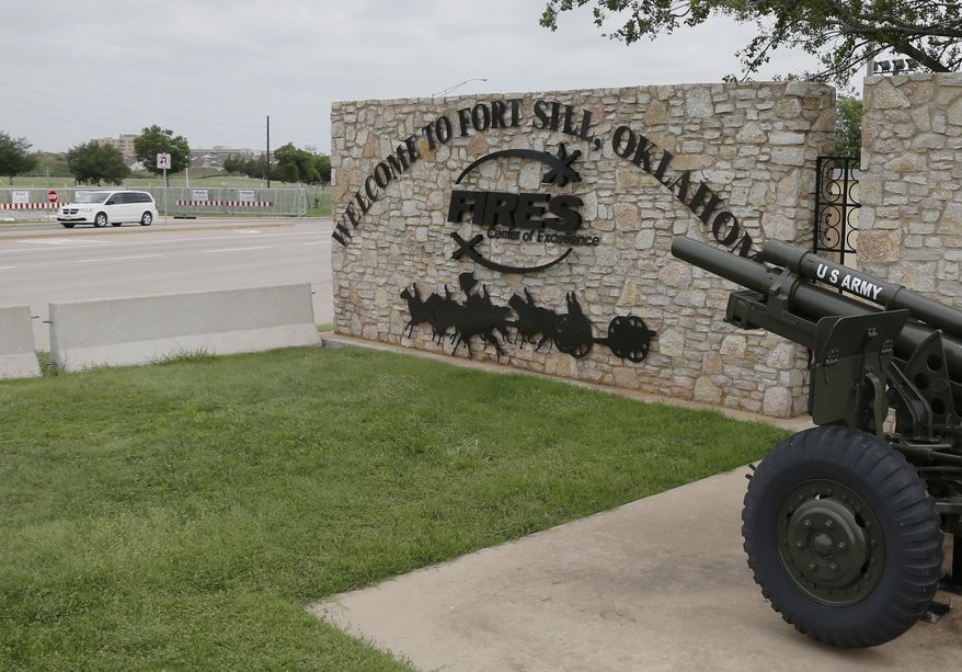 FILE - In this June 17, 2014 file photo, a vehicle drives by a sign at Scott Gate, one of the entrances to Fort Sill, in Fort Sill, Okla. The federal government has chosen Fort Sill, a military base in Oklahoma, as the location for a new temporary shelter to house migrant children. (AP Photo/Sue Ogrocki, File)
