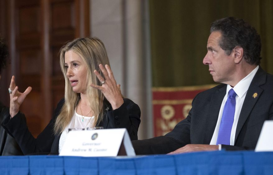 New York Gov. Andrew Cuomo, right, listens to Oscar-winning actress Mira Sorvino as she joined Times's Up advocates speaking out about sexual assault at the State Capitol in Albany, N.Y., Tuesday, June 12, 2019. Sorvino has revealed that she's a survivor of date rape in an attempt to lend her voice to a push for stronger sexual assault laws in New York. (Mike Groll/Office of Governor Andrew M. Cuomo via AP)