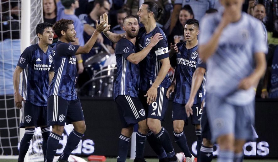 LA Galaxy forward Zlatan Ibrahimovic (9) celebrates with teammates after scoring a goal during the second half of an MLS soccer match against the Sporting Kansas City Wednesday, May 29, 2019, in Kansas City, Kan. LA Galaxy won 2-0. (AP Photo/Charlie Riedel)