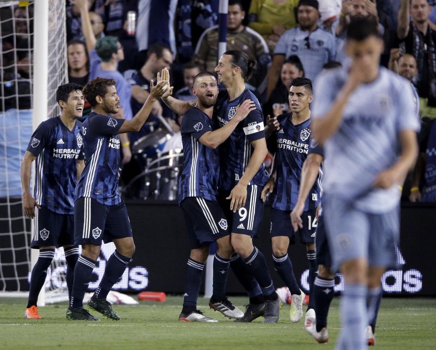 LA Galaxy forward Zlatan Ibrahimovic (9) celebrates with teammates after scoring a goal during the second half of an MLS soccer match against the Sporting Kansas City Wednesday, May 29, 2019, in Kansas City, Kan. LA Galaxy won 2-0. (AP Photo/Charlie Riedel)