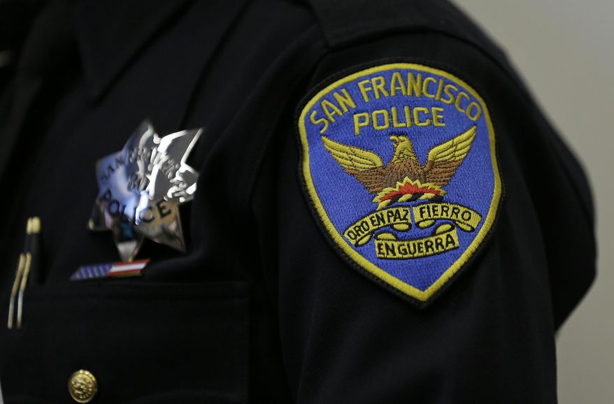 FILE - This April 29, 2016, file photo shows a patch and badge on the uniform of a San Francisco police officer in San Francisco. Twelve white male San Francisco police officers are suing the city, saying they were passed over for promotions because of their race and gender. The San Francisco Chronicle reports Wednesday, June 12, 2019, that the lawsuit, which was filed Tuesday in federal court, is the latest round in a long-running conflict. (AP Photo/Eric Risberg, File)