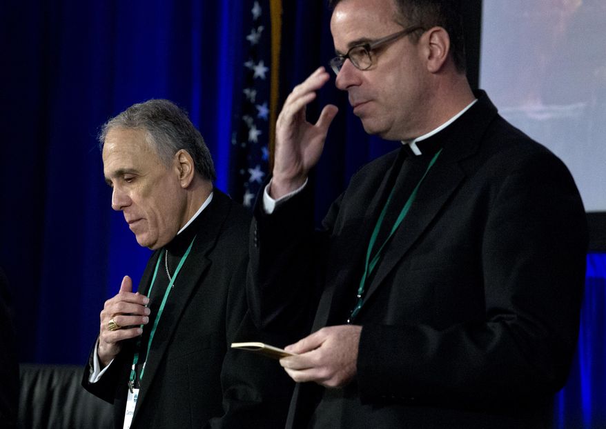 Cardinal Daniel DiNardo, left, of the Archdiocese of Galveston-Houston, president of the United States Conference of Catholic Bishops, accompanied by the Rev. J. Brian Bransfield, participates in a morning prayer, during the United States Conference of Catholic Bishops (USCCB), 2019 Spring meetings in Baltimore, Tuesday, Jun 11, 2019. (AP Photo/Jose Luis Magana)