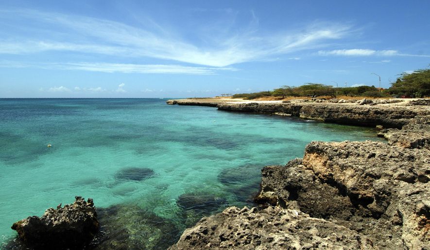 FILE - In this April 2008 file photo, crystal clear water meets the shore in Aruba. Aruba offers a sun-drenched Caribbean escape outside the hurricane belt, making this island retreat an irresistible option for late-summer travelers. (AP Photo/Shoun A. Hill, File)