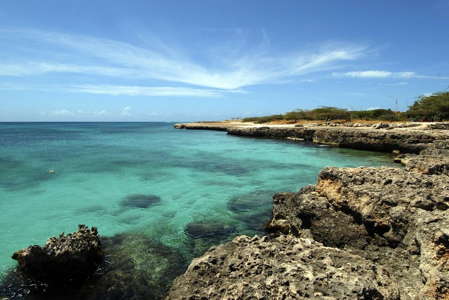 FILE - In this April 2008 file photo, crystal clear water meets the shore in Aruba. Aruba offers a sun-drenched Caribbean escape outside the hurricane belt, making this island retreat an irresistible option for late-summer travelers. (AP Photo/Shoun A. Hill, File)