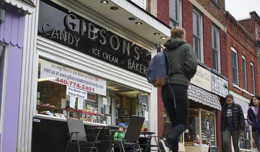 In this Nov. 22, 2017, file photo, pedestrians pass the storefront of Gibson&#39;s Food Mart &amp;amp; Bakery in Oberlin, Ohio. A jury has awarded $11 million to a father and son who claimed Ohio&#39;s Oberlin College and an administrator hurt their business and libeled them during a dispute that triggered protests and allegations of racism following a shoplifting incident. (AP Photo/Dake Kang, File) ** FILE **