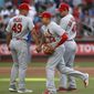 St. Louis Cardinals shortstop Yairo Munoz (34) celebrates with relief pitcher Jordan Hicks (49) and first baseman Paul Goldschmidt, right, after the Cardinals defeated the New York Mets 5-4 in the 10th inning of a baseball game Friday, June 14, 2019, in New York, that had been suspended Thursday because of rain. (AP Photo/Kathy Willens)