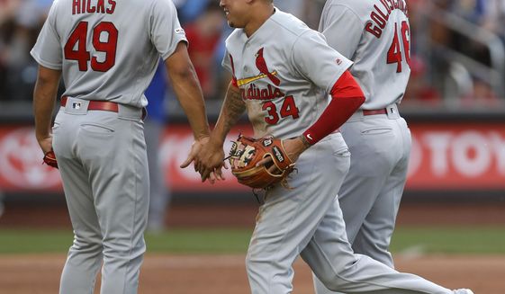 St. Louis Cardinals shortstop Yairo Munoz (34) celebrates with relief pitcher Jordan Hicks (49) and first baseman Paul Goldschmidt, right, after the Cardinals defeated the New York Mets 5-4 in the 10th inning of a baseball game Friday, June 14, 2019, in New York, that had been suspended Thursday because of rain. (AP Photo/Kathy Willens)