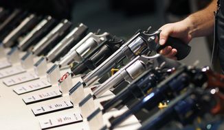 In this Jan. 19, 2016 file photo, handguns are displayed at the Smith &amp; Wesson booth at the Shooting, Hunting and Outdoor Trade Show in Las Vegas.  (AP Photo/John Locher, File) **FILE**