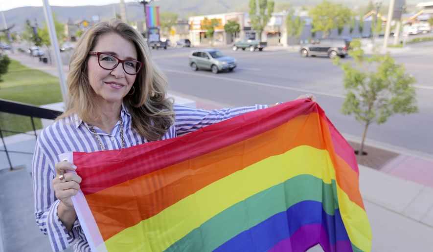 Heber City Mayor Kelleen Potter poses for a portrait in front of pride flags hanging on Main Street in Heber City, Utah on Monday, June 10, 2019.  The flags have caused a stir in the 15,000-person town and beyond, drawing attention at a Heber City Council meeting, on social media and from the American Civil Liberties Union of Utah. Some of the discussion has revolved around the flags’ message itself. But the controversy has also raised broader questions for the city about whether,  and how, to determine what kind of content can be publicly displayed on city property. (Kristin Murphy/The Deseret News via AP)