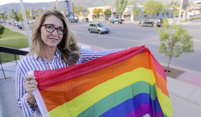 Heber City Mayor Kelleen Potter poses for a portrait in front of pride flags hanging on Main Street in Heber City, Utah on Monday, June 10, 2019.  The flags have caused a stir in the 15,000-person town and beyond, drawing attention at a Heber City Council meeting, on social media and from the American Civil Liberties Union of Utah. Some of the discussion has revolved around the flags’ message itself. But the controversy has also raised broader questions for the city about whether,  and how, to determine what kind of content can be publicly displayed on city property. (Kristin Murphy/The Deseret News via AP)