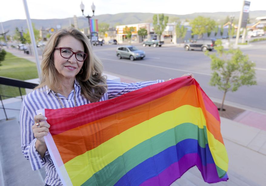 Heber City Mayor Kelleen Potter poses for a portrait in front of pride flags hanging on Main Street in Heber City, Utah on Monday, June 10, 2019.  The flags have caused a stir in the 15,000-person town and beyond, drawing attention at a Heber City Council meeting, on social media and from the American Civil Liberties Union of Utah. Some of the discussion has revolved around the flags’ message itself. But the controversy has also raised broader questions for the city about whether,  and how, to determine what kind of content can be publicly displayed on city property. (Kristin Murphy/The Deseret News via AP)