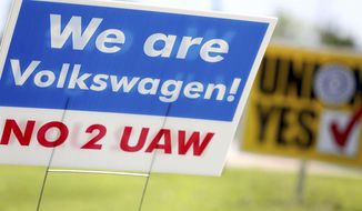 Signs for and against unionization are in a roundabout along Volkswagen Drive in front of the Volkswagen plant Friday, June 14, 2019 in Chattanooga, Tenn. Workers voted against forming a factory-wide union, handing a setback to the United Auto Workers’ efforts to gain a foothold among foreign auto facilities in the South. (Erin O. Smith/Chattanooga Times Free Press via AP)