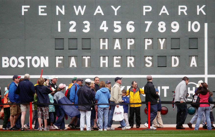 FILE - In this June 21, 2009 file photo, fans tour in front of the scoreboard in Fenway Park in Boston in celebration of Father's Day following a baseball game between the Atlanta Braves and the Boston Red Sox. The U.S. Census Bureau has released a new report showing more than 60% of the 121 million men in the U.S. are fathers. The data in the report released this week of June 15, 2019, comes from 2014 when the bureau for the first time asked both men and women about their fertility histories. The report says just under three-quarters of fathers are married. Almost 13% of dads are divorced and 8% have never been married. (AP Photo/Michael Dwyer)