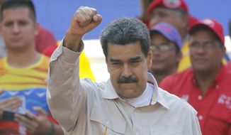 In this April 6, 2019, photo, Venezuela&#39;s President Nicolas Maduro raises his fist to supporters rallying at the presidential palace in Caracas, Venezuela. (AP Photo/Ariana Cubillos) **FILE**