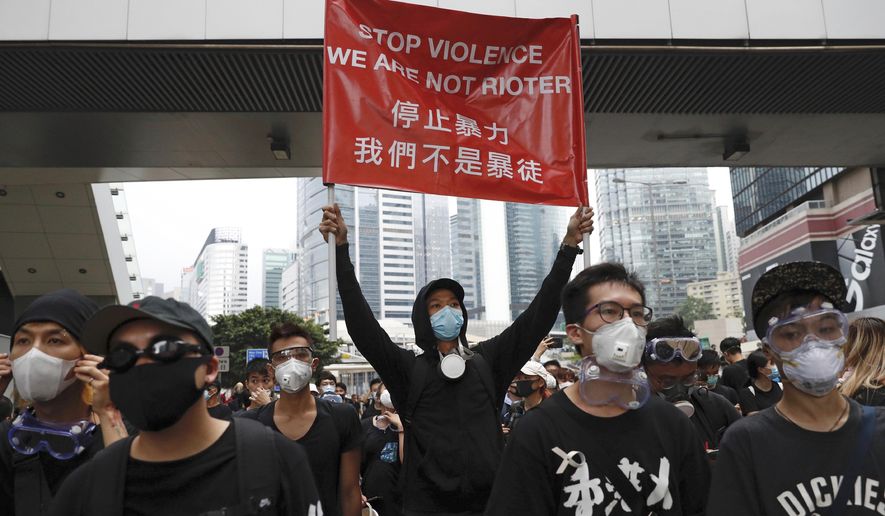 Protesters hold a banner during a march toward the Legislative Council as they continue to protest against the extradition bill in Hong Kong, Monday, June 17, 2019. Hong Kong police announced that they want to clear the streets of protesters Monday morning. Soon after, police lined up several officers deep and faced off against several hundred demonstrators on a street in central Hong Kong. (AP Photo/Vincent Yu)