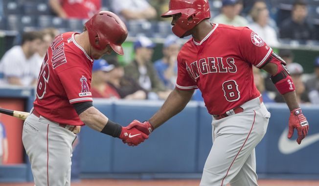 Los Angeles Angels&#x27; Justin Upton (8) is greeted by teammate Kole Calhoun after hitting a home run against the Toronto Blue Jays during second-inning baseball game action in Toronto, Monday, June 17, 2019. (Fred Thornhill/The Canadian Press via AP)