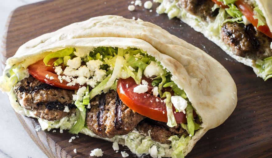 This undated photo provided by America's Test Kitchen in June 2019 shows a Grilled Greek-Style Lamb Pita in Brookline, Mass. This recipe appears in “The Complete Mediterranean Cookbook.” (Carl Tremblay/America's Test Kitchen via AP)