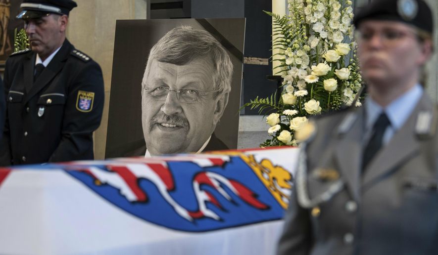 FILE-In this June 13, 2019 file photo a picture of Walter Luebcke stands behind his coffin during the funeral service in Kassel, Germany. German authorities say they have arrested a 45-year-old man in connection with their investigation into the slaying of a regional official from Chancellor Angela Merkel’s party. (Swen Pfoertner/dpa via AP)