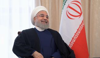 Iranian President Hassan Rouhani smiles as he speaks to Russian President Vladimir Putin during their talks on a sideline of the Shanghai Cooperation Organization summit in Bishkek, Kyrgyzstan, Friday, June 14, 2019. Iran&#39;s President Hassan Rouhani has called for closer cooperation between Tehran and Moscow amid rising regional tensions. (Alexei Druzhinin, Sputnik, Kremlin Pool Photo via AP)