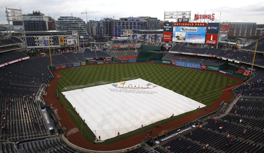 A tarp covers the infield during a rain delay before a baseball game between the Philadelphia Phillies and the Washington Nationals, Monday, June 17, 2019, in Washington. (AP Photo/Patrick Semansky)