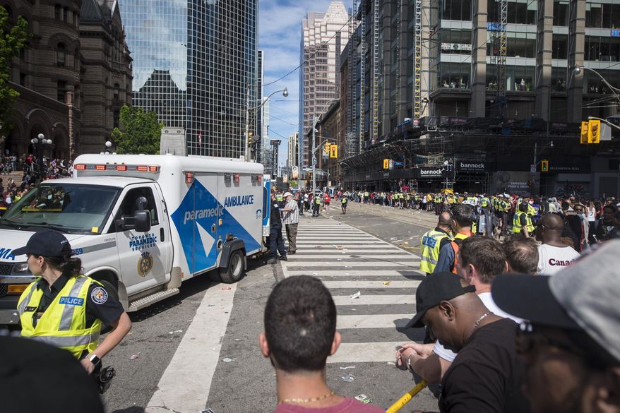 An ambulance arrives to the scene after shots were fired during the Toronto Raptors NBA basketball championship victory celebration near Nathan Phillips Square in Toronto, Monday, June 17, 2019. (Tijana Martin/The Canadian Press via AP)
