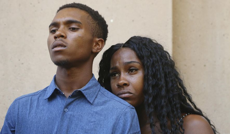 Dravon Ames, left, and Iesha Harper pause as they listen to a question during a news conference at Phoenix City Hall, Monday, June 17, 2019, in Phoenix. Ames and his pregnant fiancée, Harper, who had guns aimed at them by Phoenix police during a response to a shoplifting report say they don't accept the apologies of the city's police chief and mayor and want the officers involved to be fired.(AP Photo/Ross D. Franklin)