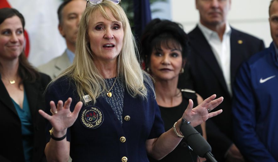 Nancy Hogshead-Makar, front, who won four medals in the Summer Olympics for the United States in 1984, makes a point as Judge Rosemarie Aquilina, back, who sentenced former USA Gymnastics team doctor Larry Nasser to 175 years in prison, looks on during a news conference to announce a plan to introduce legislation aimed at reforming the U.S. Olympic Committee Monday, June 17, 2019, in Denver. Nearly a dozen Olympic athletes were on hand to lend their support to the measure, which U.S. Rep. Diana DeGette, D-Colo., plans to introduce this week. (AP Photo/David Zalubowski)