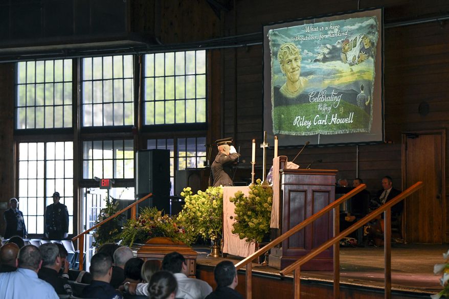 FILE - In this May 5, 2019 file photo, a United States military honor guard salutes a U.S. flag to be presented to the parents of Riley Howell during his memorial service in Lake Junaluska, N.C. Howell, the student credited with tackling a gunman during a fatal North Carolina campus rampage suffered eight gunshot wounds, and another slain student was shot six times, according to an autopsy released Tuesday, June 18. The autopsy made public by the Office of the Chief Medical Examiner said Riley Howell had four wounds to the head or neck, two to the chest and one on each arm during the April 30 shooting at UNC-Charlotte that killed two and wounded four. (AP Photo/Kathy Kmonicek)