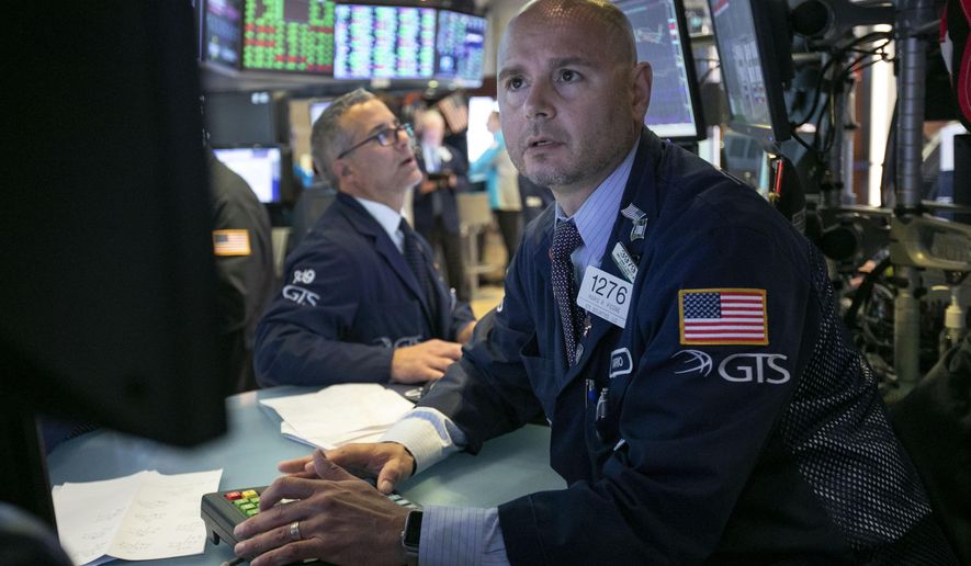 FILE- In this June 11, 2019, file photo specialist Mario Picone, right, works at his post on the floor of the New York Stock Exchange. The U.S. stock market opens at 9:30 a.m. EDT on Tuesday, June 18. (AP Photo/Richard Drew, File)