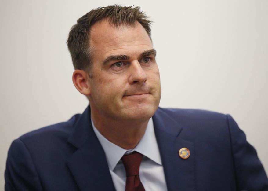 FILE - In this May 9, 2019 file photo, Oklahoma Gov. Kevin Stitt listens to a question during a news conference in Oklahoma City. A hearing is being held Tuesday, June 18, 2019, before the Oklahoma Supreme Court on whether a group that supports expanding Medicaid can start gathering signatures to place the issue on the ballot in 2020. Opponents, including Gov. Stitt and most Republicans, say the cost to the state, even with a 9-to-1 federal match, is a significant investment and raised concerns about what will happen if the state's share must increase in future years. (AP Photo/Sue Ogrocki, File)