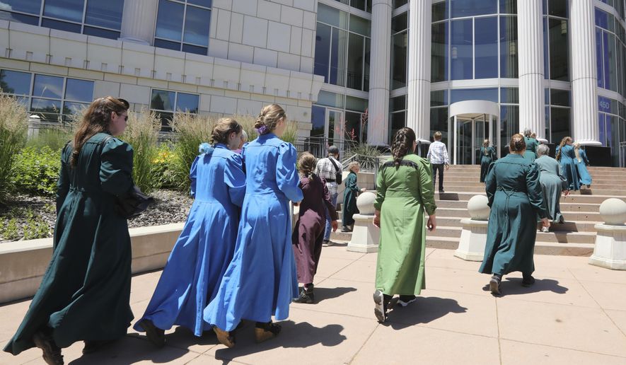 People arrive at the Matheson Courthouse Tuesday, June 18, 2019, in Salt Lake City. Members of a community on the Utah-Arizona border that is home to Warren Jeffs' polygamous sect are expected to raise concerns with a judge about favoritism and a lack of transparency by a board that oversees a former church trust that manages evictions and resales of homes and properties in the sister cities of Hildale, Utah, and Colorado City, Arizona. (AP Photo/Rick Bowmer)