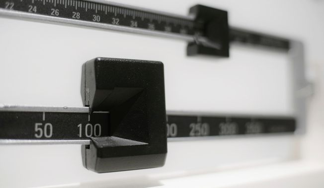 This April 3, 2018, file photo shows a closeup of a beam scale in New York. A study released on Tuesday, June 18, 2019, found U.S. preschoolers on government food aid have grown a little less pudgy, offering fresh evidence that previous signs of shrinking obesity weren’t a fluke. Obesity rates dropped to about 14 percent in 2016, the latest data available and a steady decline from 16 percent in 2010, researchers from the federal Centers for Disease Control and Prevention reported.  (AP Photo/Patrick Sison, File) ** FILE **